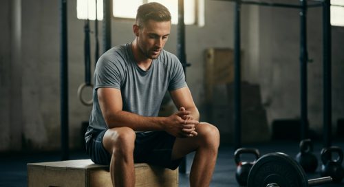 Ein Hardgainer betrachtet nach dem Crosstraining zufrieden seine Fortschritte in einer Crossfit Box. Ein Hardgainer betrachtet nach dem Crosstraining zufrieden seine Fortschritte in einer Crossfit Box.