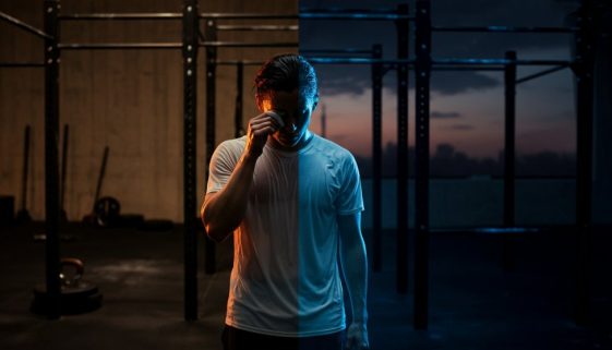Ein Athlet steht nachdenklich an einem Scheideweg im Crosstraining vs Calisthenics Vergleich.