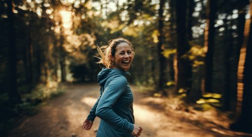 Eine Läuferin hat sichtlich Spaß bei ihrem Fartlek Training auf einem Waldweg. Eine Läuferin hat sichtlich Spaß bei ihrem Fartlek Training auf einem Waldweg.