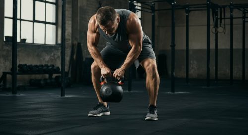Athlet beim funktionellen Bodybuilding: Führt eine kraftvolle Übung mit einer Kettlebell aus. Athlet beim funktionellen Bodybuilding: Führt eine kraftvolle Übung mit einer Kettlebell aus.
