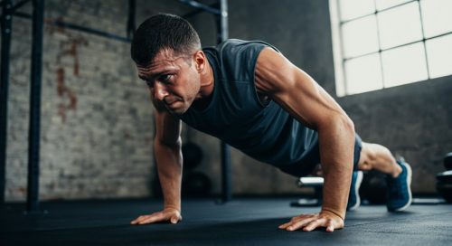 Ein Athlet in der anstrengendsten Phase einer Handstand Push Up Progression an einer Ziegelsteinwand, hochkonzentriert. Ein Athlet in der anstrengendsten Phase einer Handstand Push Up Progression an einer Ziegelsteinwand, hochkonzentriert.