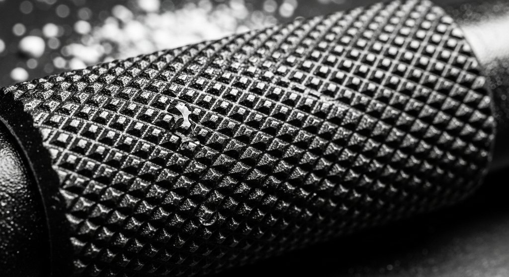 Detailaufnahme der griffigen RĂ€ndelung einer professionellen Langhantel fĂŒr Crosstraining.