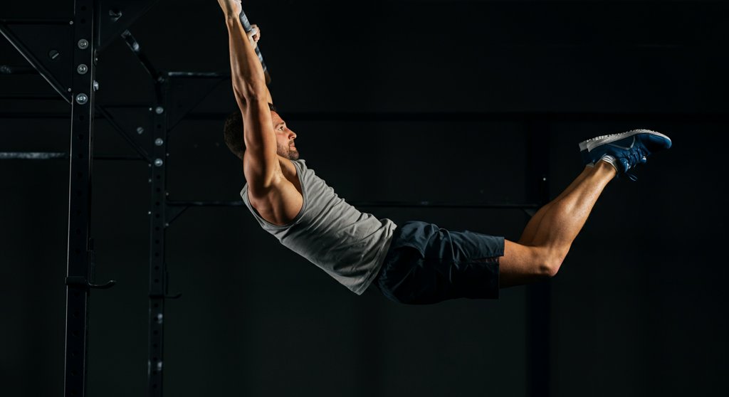 Häufiger Fehler beim Kipping Pull Up: unkontrollierter Schwung aus den Beinen.