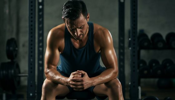 Erschöpfter, aber entschlossener Athlet nach dem Training mit Reduktionssätzen.